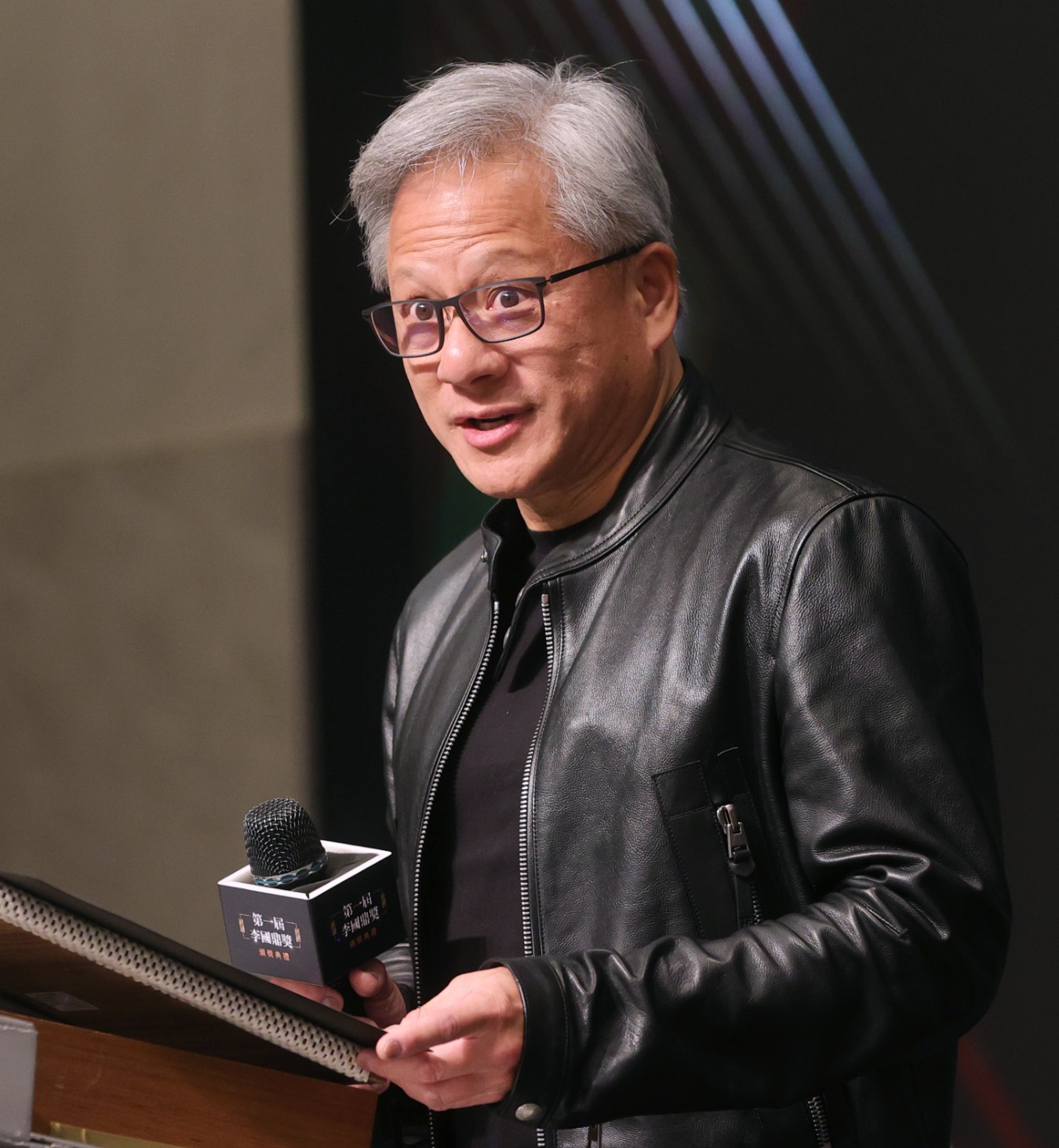 Jensen Huang, in his trademark leather jacket, speaking at an awards ceremony in Taiwan