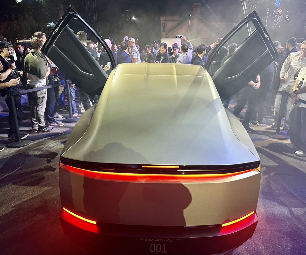 The rear of a Tesla Cybercab with its butterfly doors open