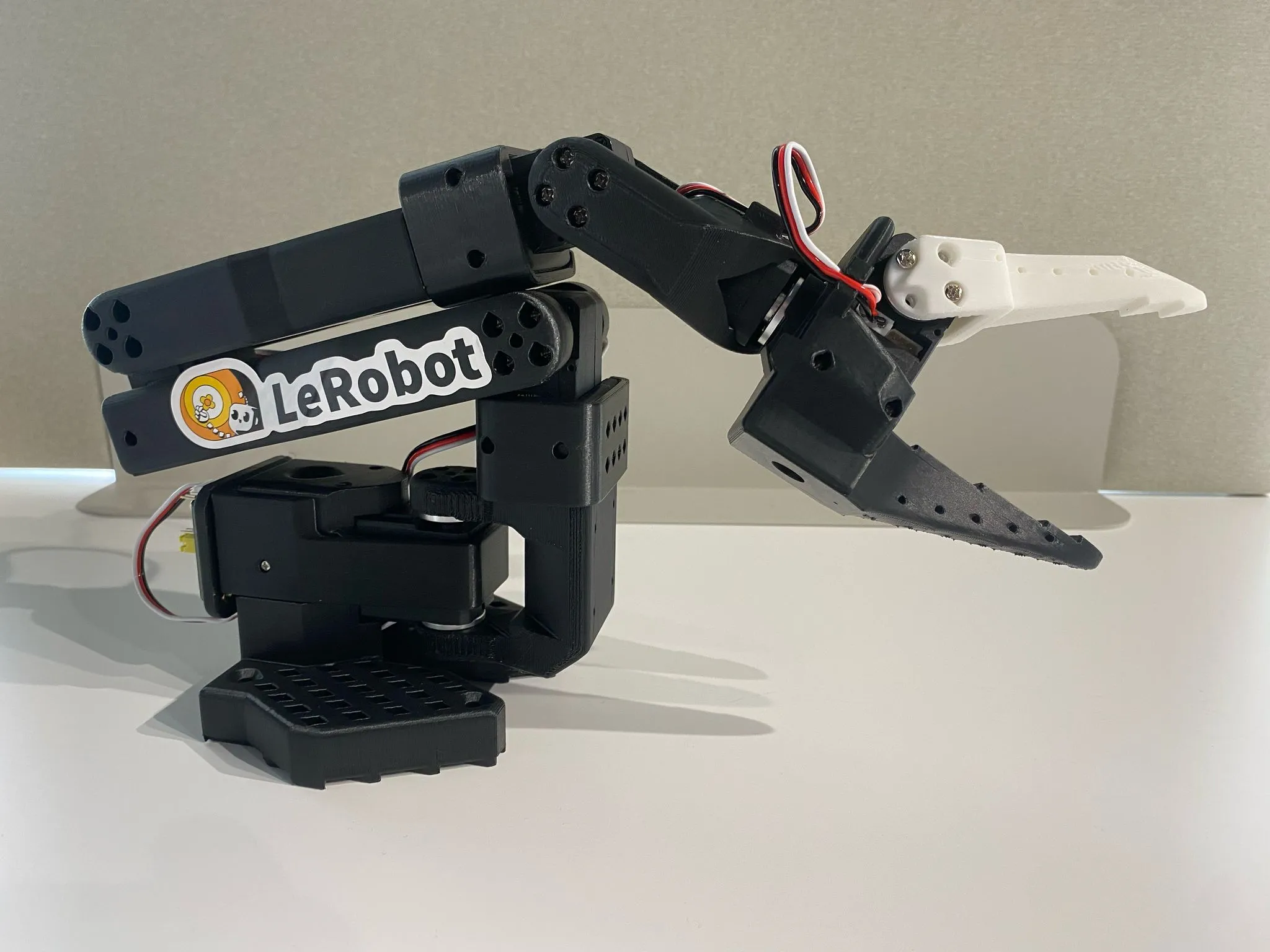 Assembled SO-101 follower arm, with a two-jaw gripper claw and a LeRobot sticker