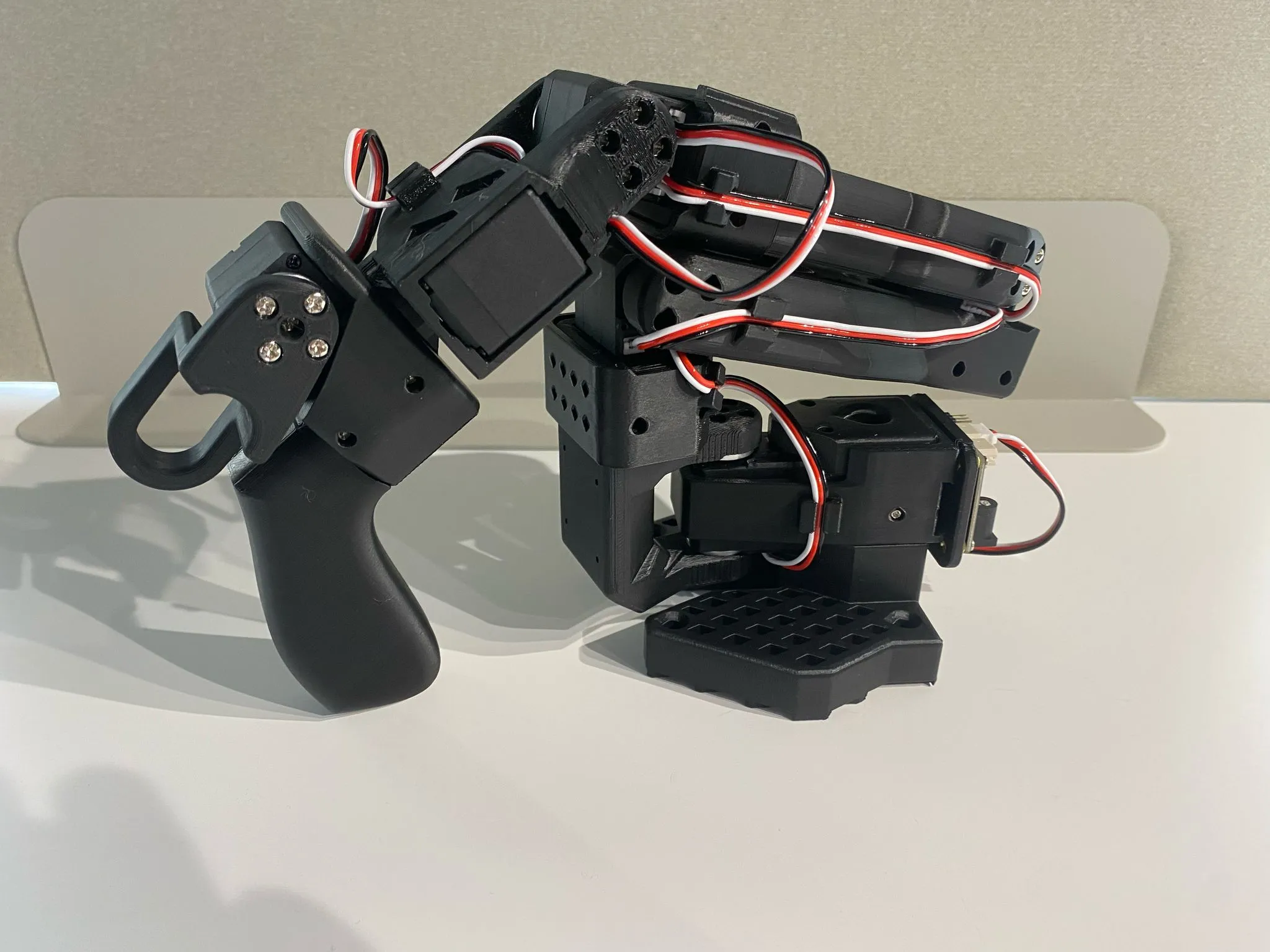The SO-101 leader arm, with a molded handle and trigger instead of a gripper claw