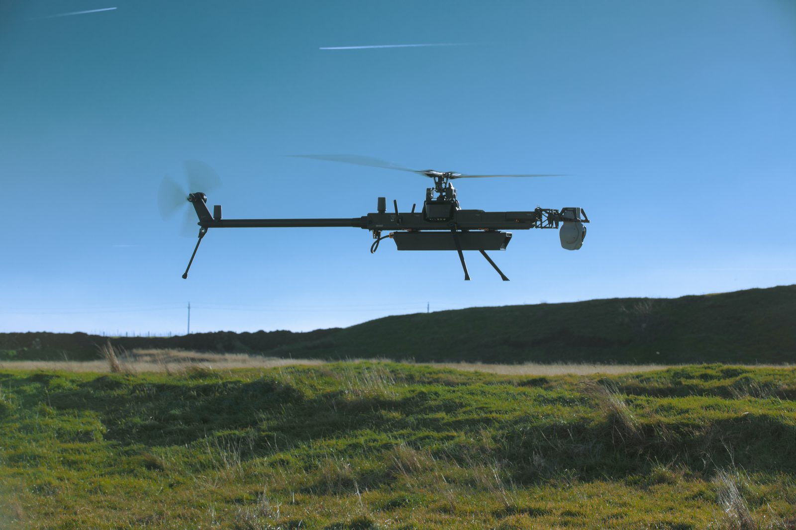 An Anduril Ghost-X unmanned aircraft system in flight near a US military air base