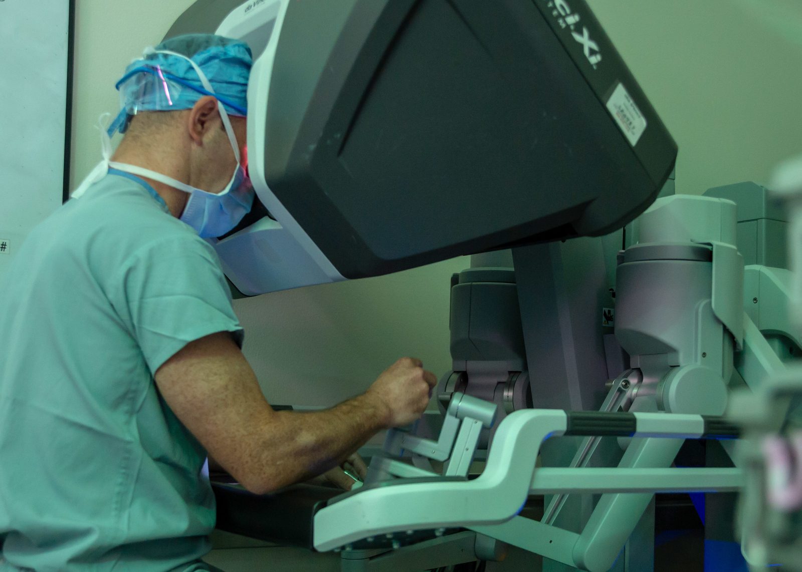 A surgeon operating a robotic surgery console