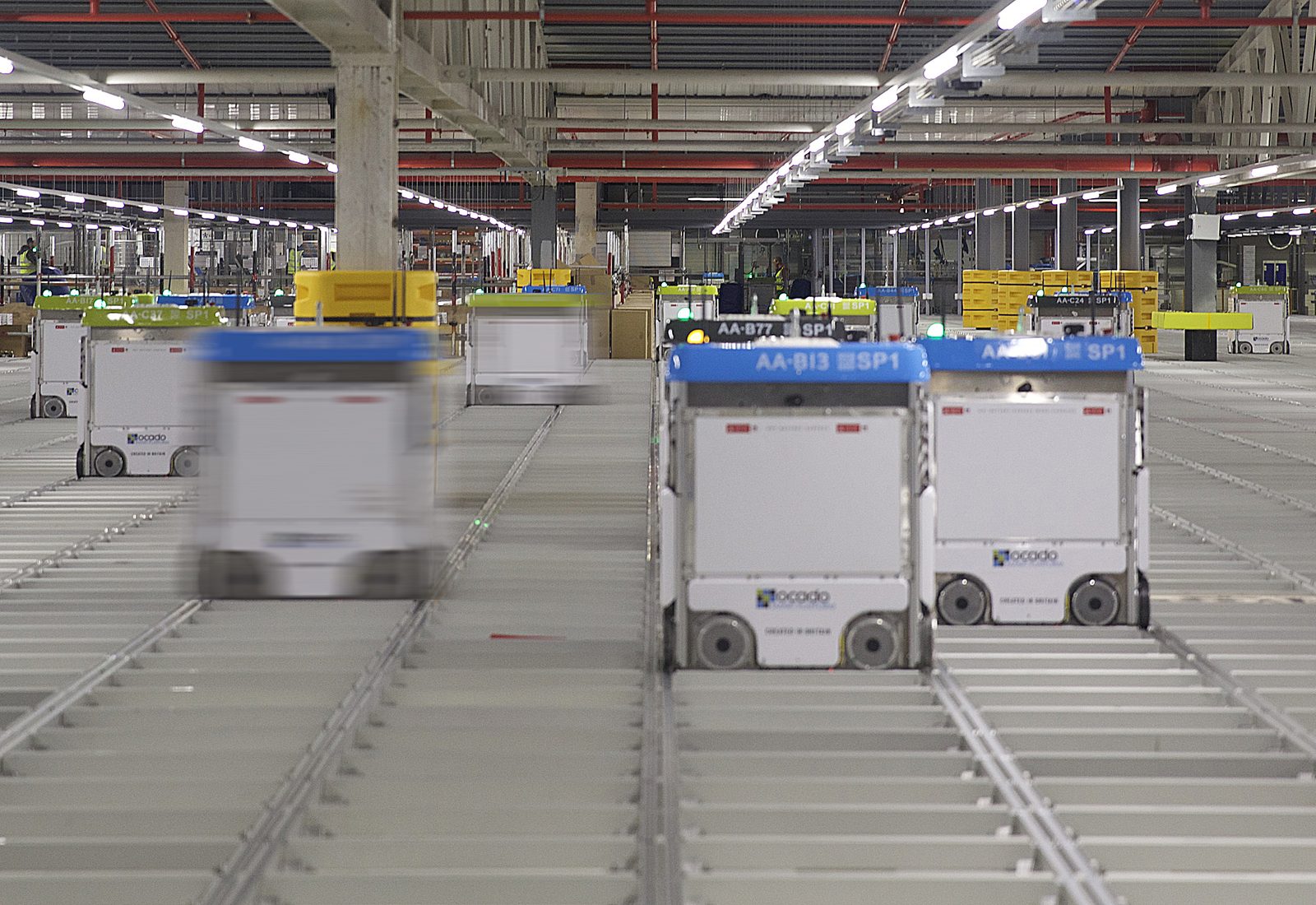 A swarm of Ocado grid robots moving across a storage grid at an automated warehouse